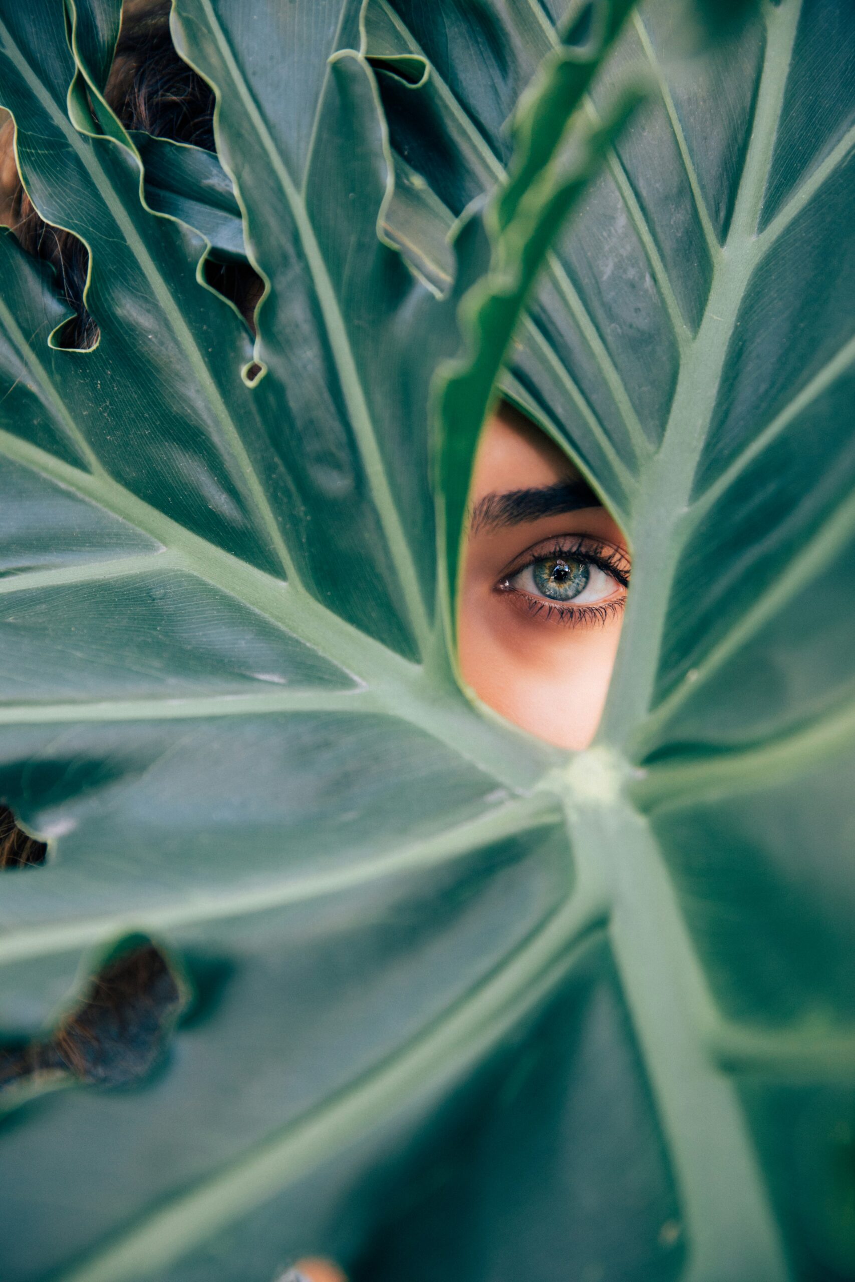 Woman peaking through a leaf